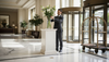 Concierge arranging lilies in marble hotel foyer