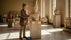 Museum curator tending marble bust historic display