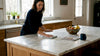 Homeowner cleaning marble counter with visible veining
