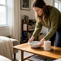 Homeowner arranges stone homeware on table