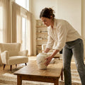 Woman placing artisanal stone vase in living room