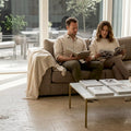 Couple relaxing in travertine-tiled living room