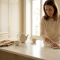 Woman cleaning marble kitchen island surface