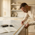 Homeowner installing lighting under marble island
